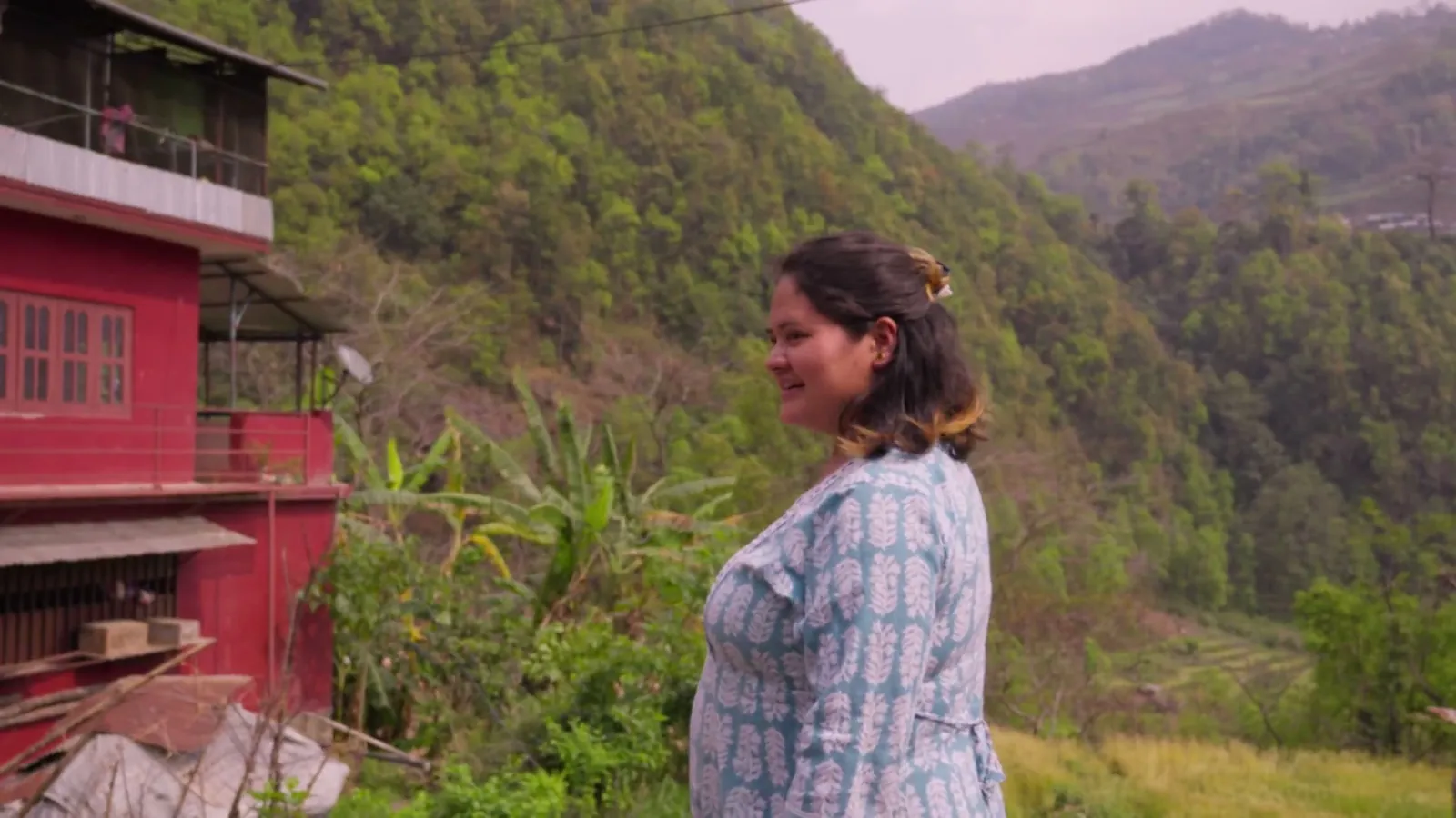 Anjali em pé diante das montanhas do Nepal, perto da escola Hasta